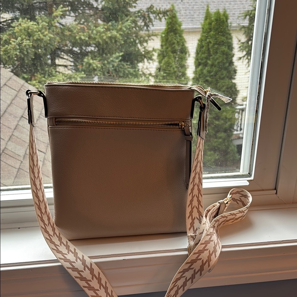 Women’s Tan Purse. Side has zipper pocket. Plenty of space inside.No name brand.